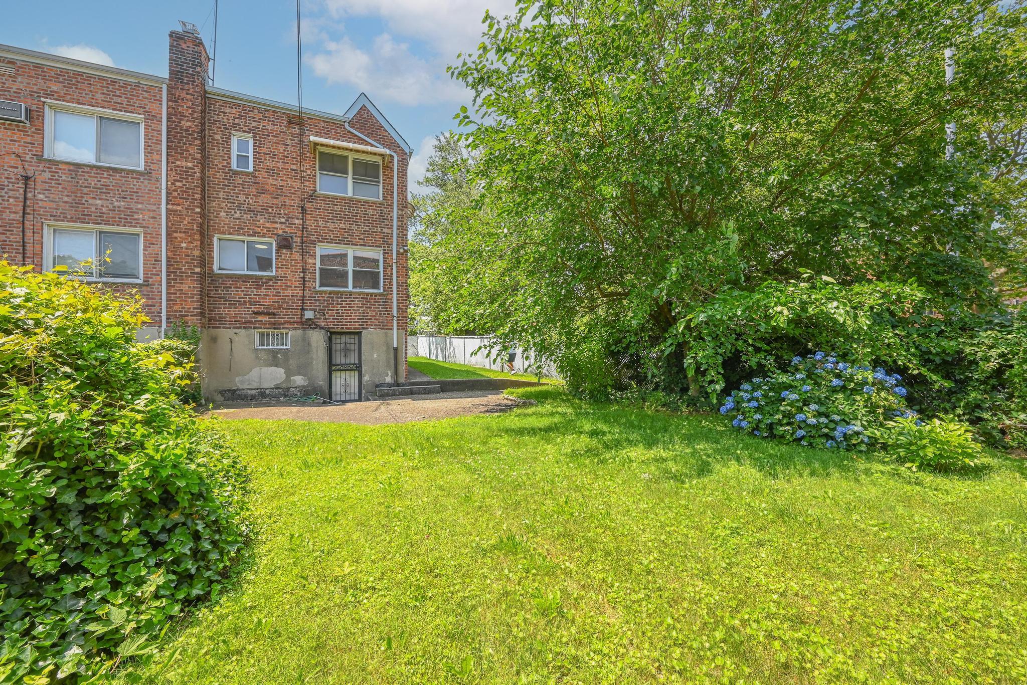 150-01 Horace Harding Expressway Queens, NY 11367 - Photo 11 of 17 Back of property with brick siding and a chimney
