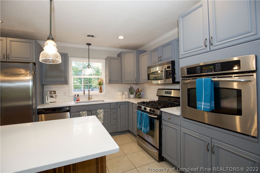 321 Pinecrest Court Road Aberdeen, NC 28315 - Photo 11 of 50 a kitchen with stainless steel appliances granite countertop a stove sink microwave and refrigerator