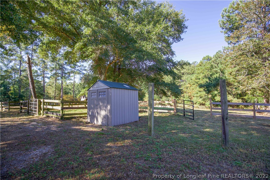 321 Pinecrest Court Road Aberdeen, NC 28315 - Photo 48 of 50 a view of a backyard with large trees and wooden fence
