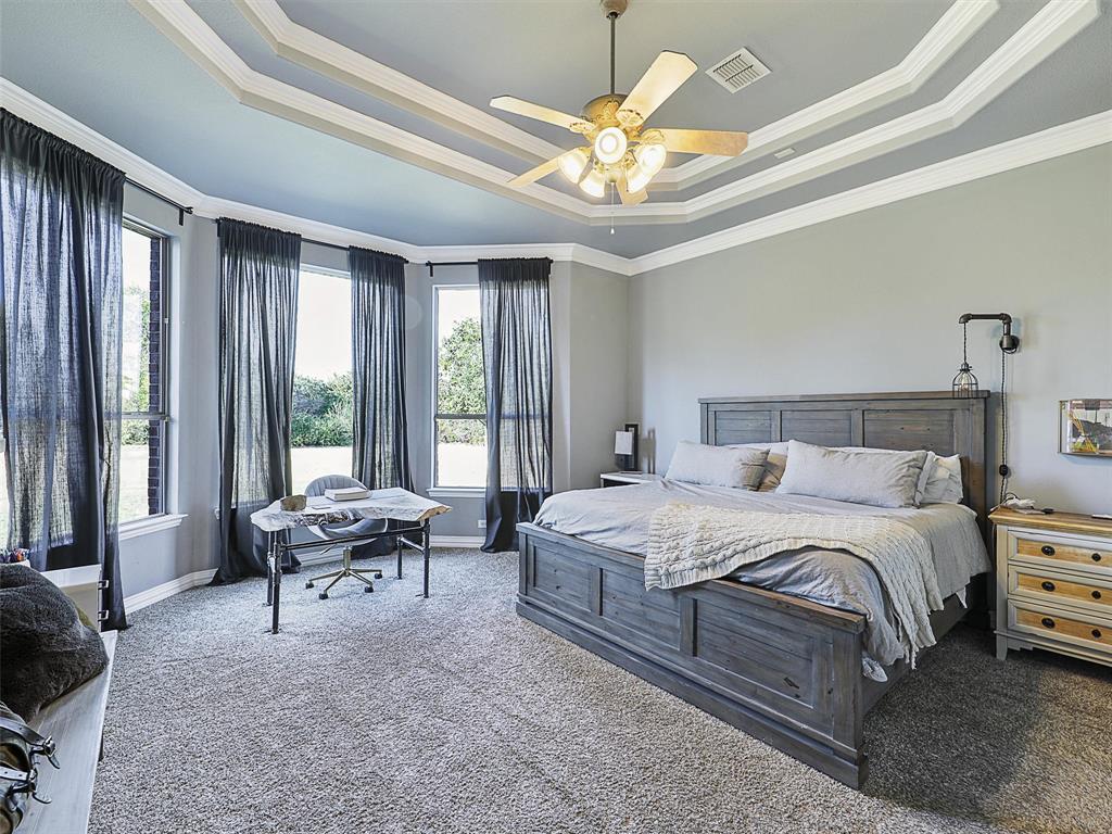 671 Countryside Drive Fairview, TX 75069 - Photo 12 of 32 a spacious bedroom with a bed and a chandelier