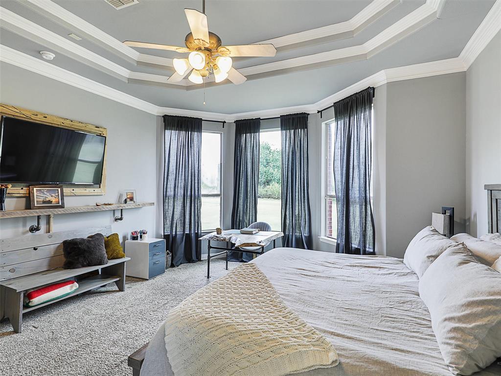 671 Countryside Drive Fairview, TX 75069 - Photo 13 of 32 a bedroom with a bed and a flat tv screen on dresser