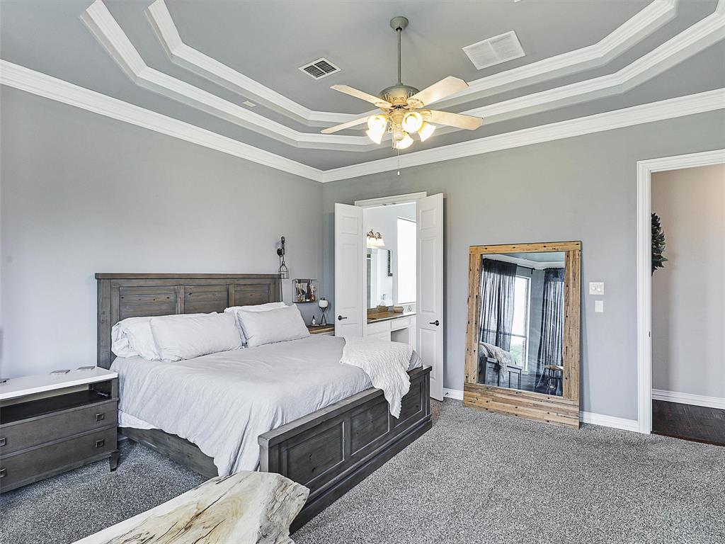 671 Countryside Drive Fairview, TX 75069 - Photo 14 of 32 a spacious bedroom with a bed and a chandelier