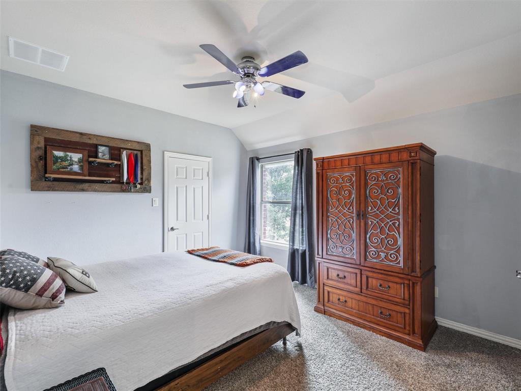 671 Countryside Drive Fairview, TX 75069 - Photo 29 of 32 a bedroom with a large bed and a chandelier