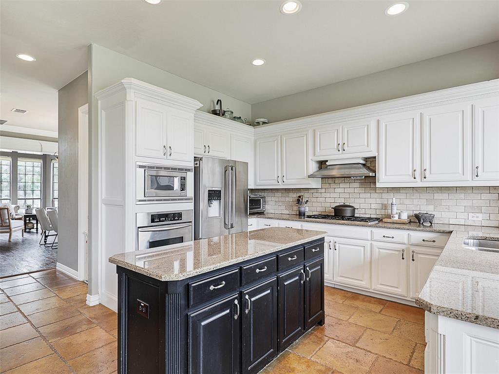 671 Countryside Drive Fairview, TX 75069 - Photo 7 of 32 a kitchen with stainless steel appliances granite countertop a stove top oven a sink a refrigerator and white cabinets