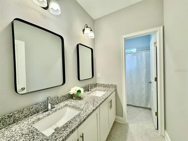 a bathroom with double vanity sinks and a mirror