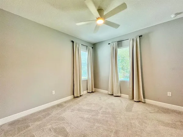 an empty room with closet and a ceiling fan