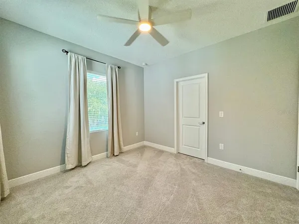 an empty room with closet and a chandelier fan