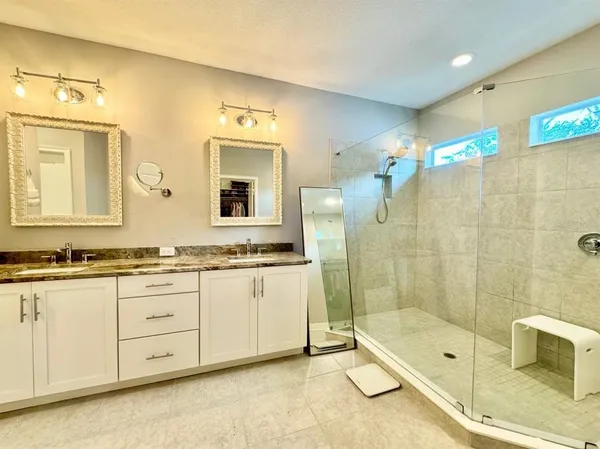 a bathroom with a granite countertop sink mirror and bathtub