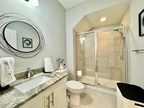 a bathroom with a granite countertop sink mirror vanity and toilet