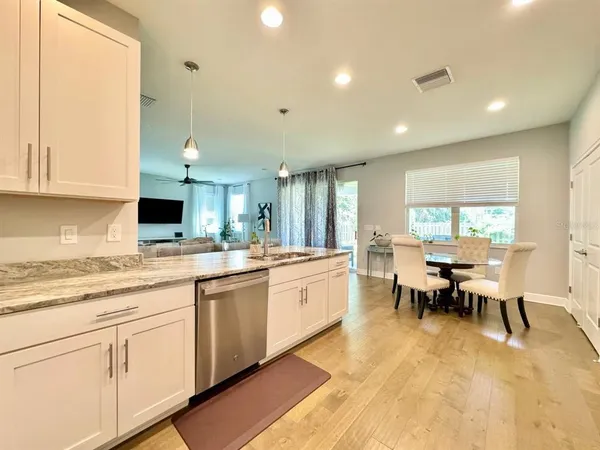 a large kitchen with kitchen island a sink table and chairs
