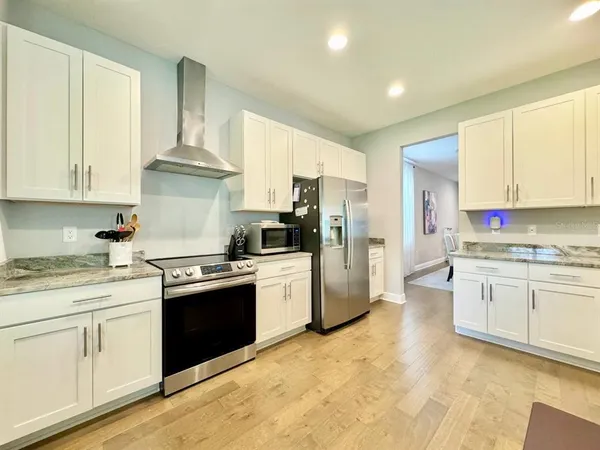 a kitchen with stainless steel appliances granite countertop a stove a sink dishwasher and a refrigerator