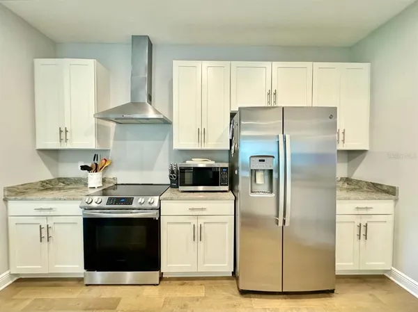 a kitchen with white cabinets and stainless steel appliances