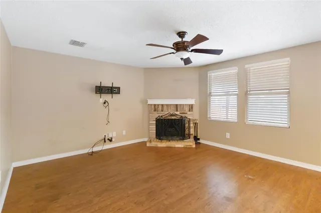 a view of an empty room with a fireplace and a window