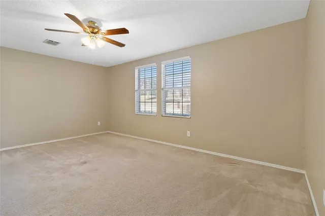 an empty room with a window and a fan