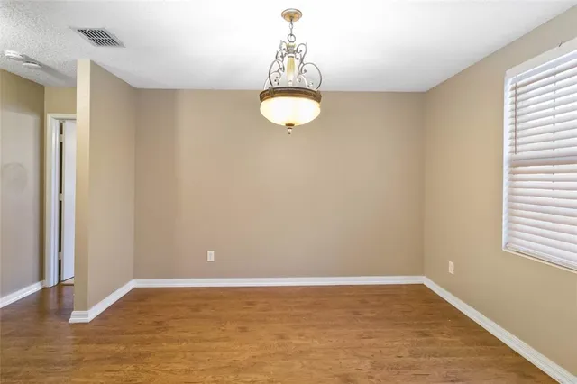 a view of a room with wooden floor and chandelier
