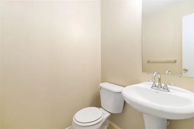 a white toilet sitting next to a white sink