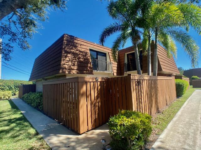 3900 County Line Road, Unit 2D Tequesta, FL 33469 - Photo 1 of 19 a view of a house with a large window and potted plants