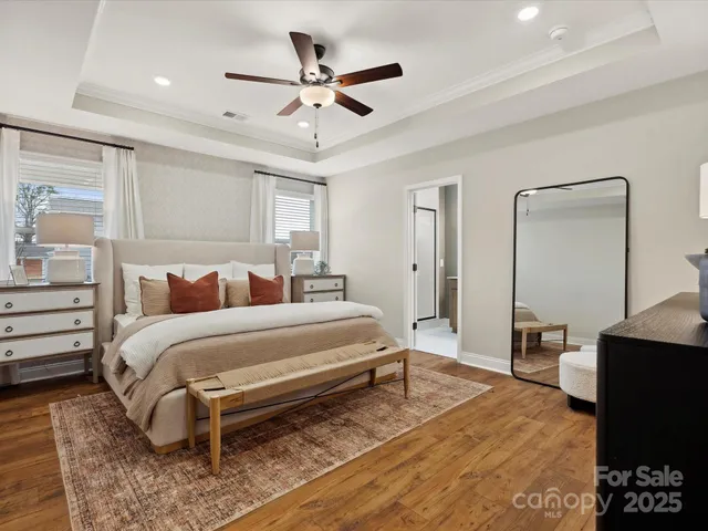 a spacious bedroom with a bed a dresser and potted plant