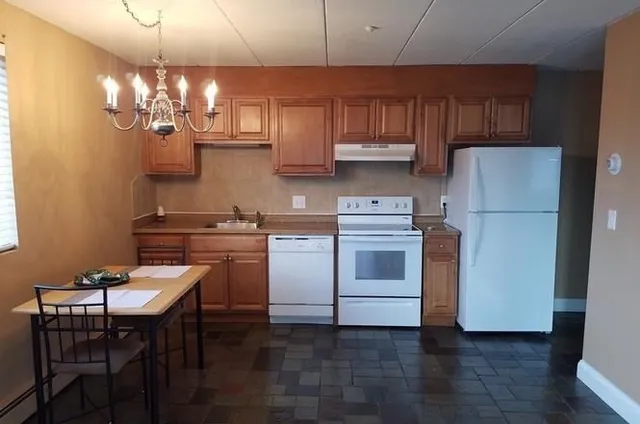 a kitchen with cabinets wooden floor and stainless steel appliances