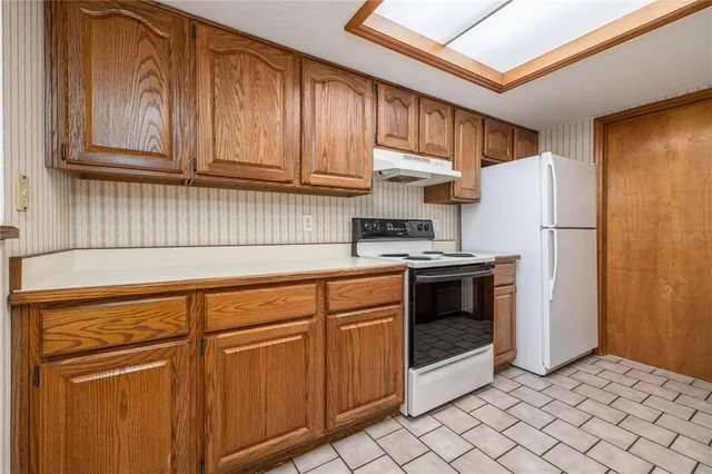 a kitchen with stainless steel appliances granite countertop a refrigerator and cabinets