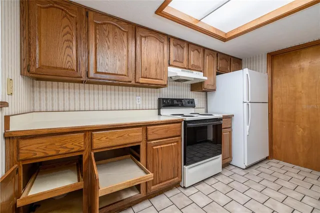 a kitchen with stainless steel appliances granite countertop a refrigerator and a stove top oven