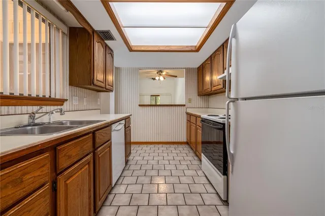 a kitchen with a sink a stove top oven and cabinetry