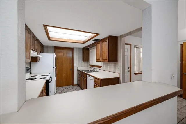 a kitchen with stainless steel appliances kitchen island a refrigerator sink and stove