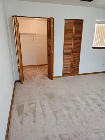 an empty room with closet and mirror