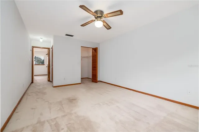 an empty room with closet and fan