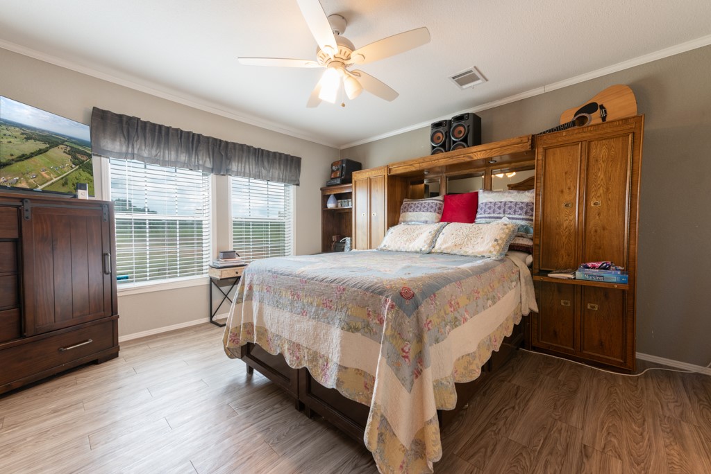 859 Ivy Switch Road Luling, TX 78648 - Photo 15 of 29 Bedroom with light wood finished floors, ornamental molding, and a ceiling fan