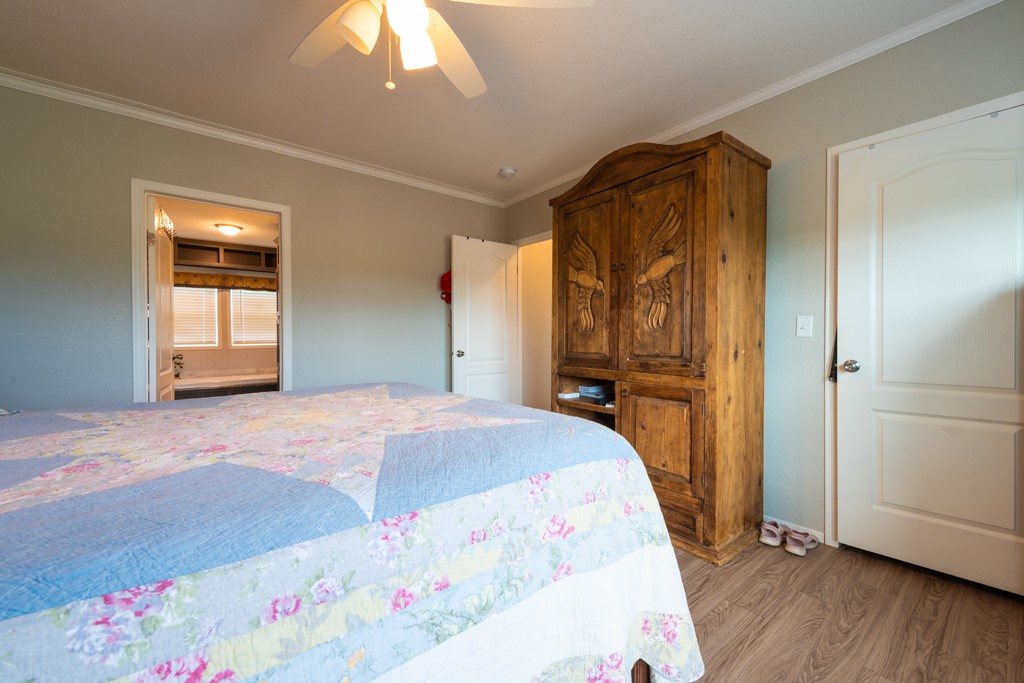 859 Ivy Switch Road Luling, TX 78648 - Photo 16 of 29 Bedroom featuring crown molding, wood finished floors, and a ceiling fan