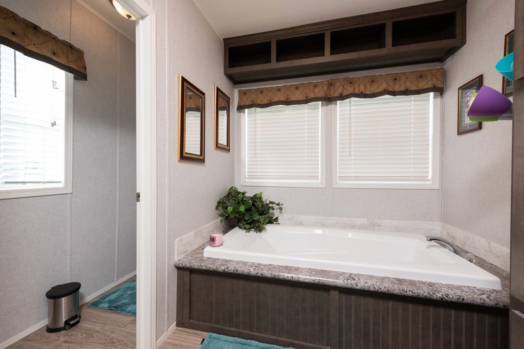 859 Ivy Switch Road Luling, TX 78648 - Photo 18 of 29 Bathroom with light wood-style flooring, a bath, and healthy amount of natural light