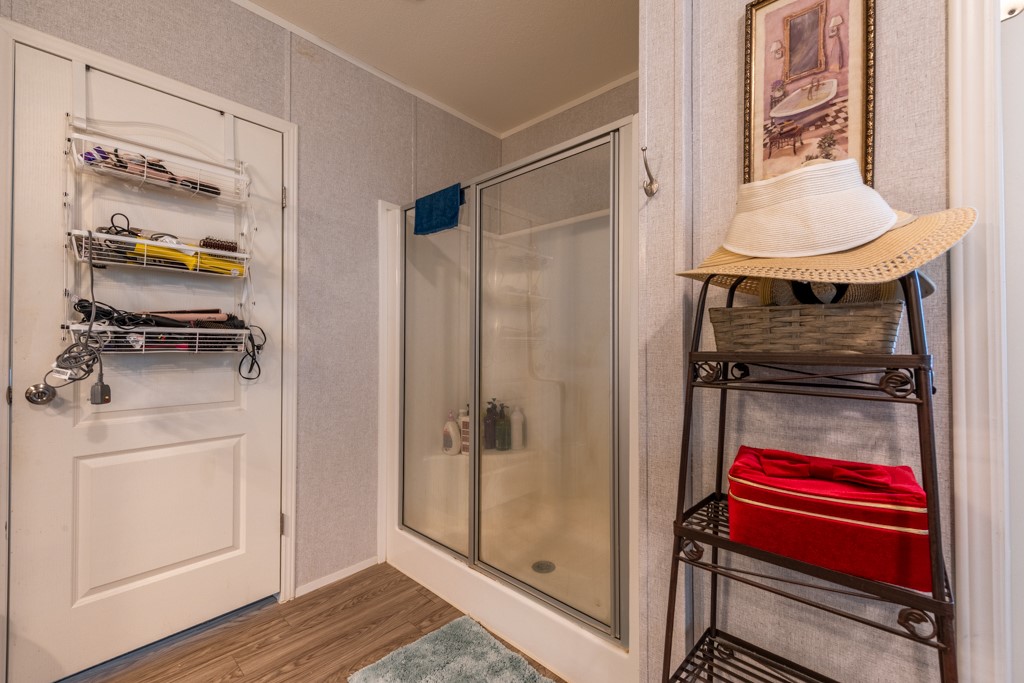 859 Ivy Switch Road Luling, TX 78648 - Photo 19 of 29 Full bath with wood finished floors, a stall shower, and crown molding