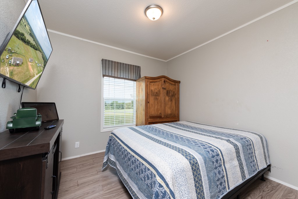 859 Ivy Switch Road Luling, TX 78648 - Photo 20 of 29 Bedroom featuring light wood-style flooring and ornamental molding