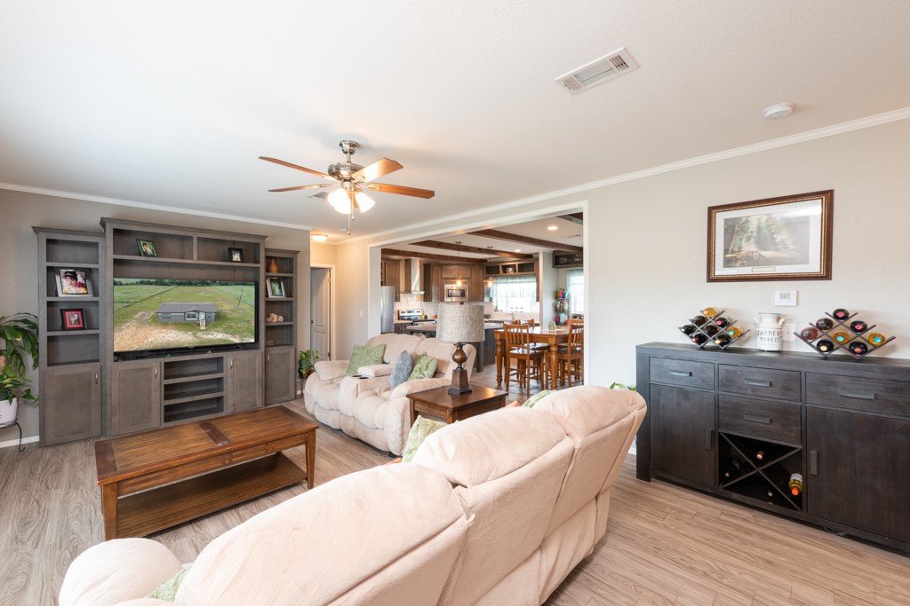 859 Ivy Switch Road Luling, TX 78648 - Photo 9 of 29 Living room featuring light wood-type flooring, crown molding, a ceiling fan, and recessed lighting