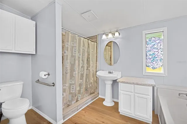 a spacious bathroom with a toilet a sink and a mirror