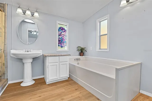 a spacious bathroom with a sink a mirror and a bathtub