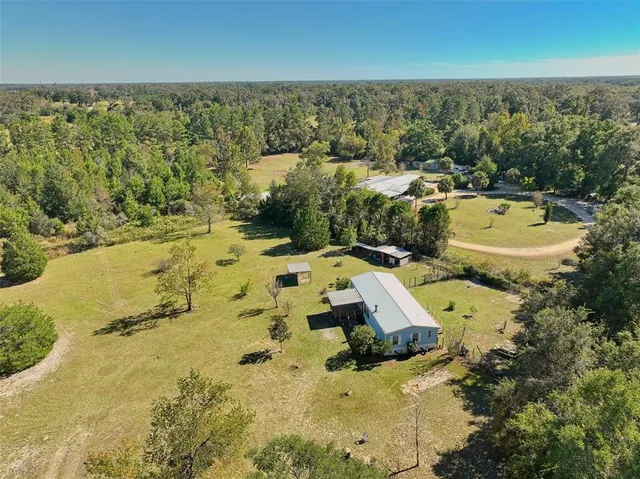 an aerial view of a house with a yard and lake view