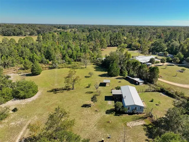 an aerial view of a house with a yard and lake view