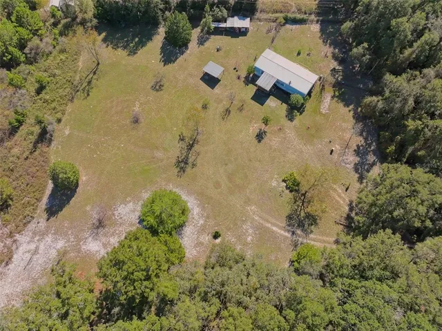 an aerial view of a house with a yard and lake view