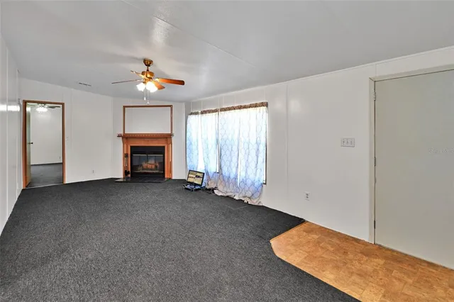 an empty room with windows and fireplace