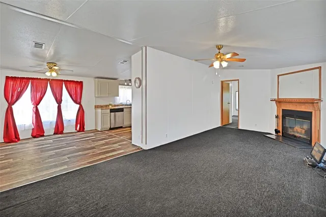 a view of empty room with a fireplace cabinet and windows