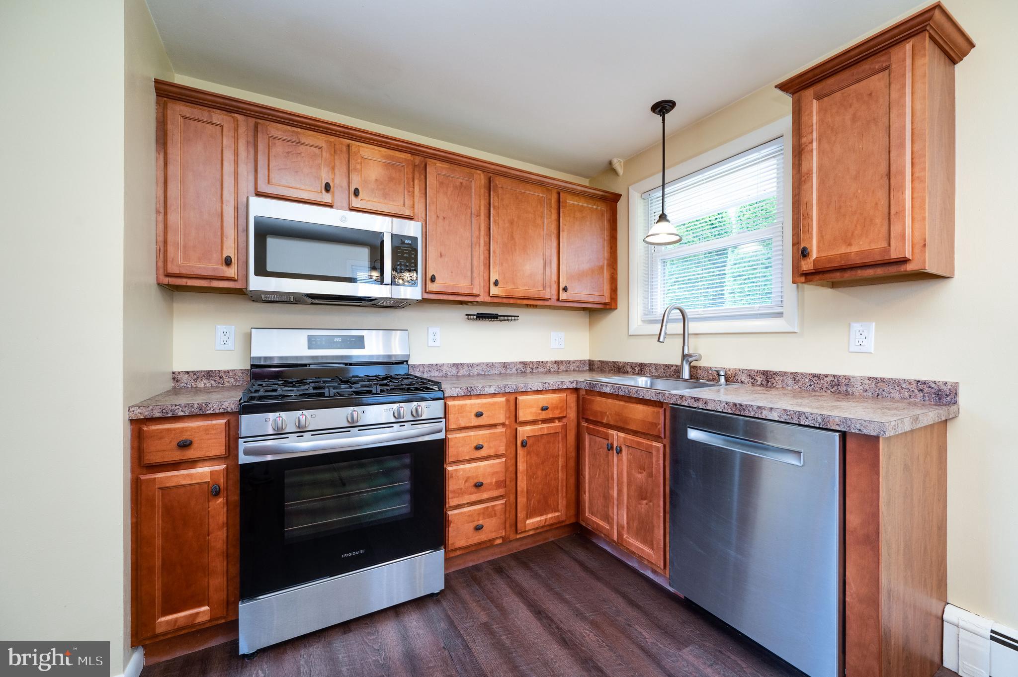 1392 New Holland Road Reading, PA 19607 - Photo 13 of 27 a kitchen with stainless steel appliances granite countertop wooden cabinets stove top oven and sink