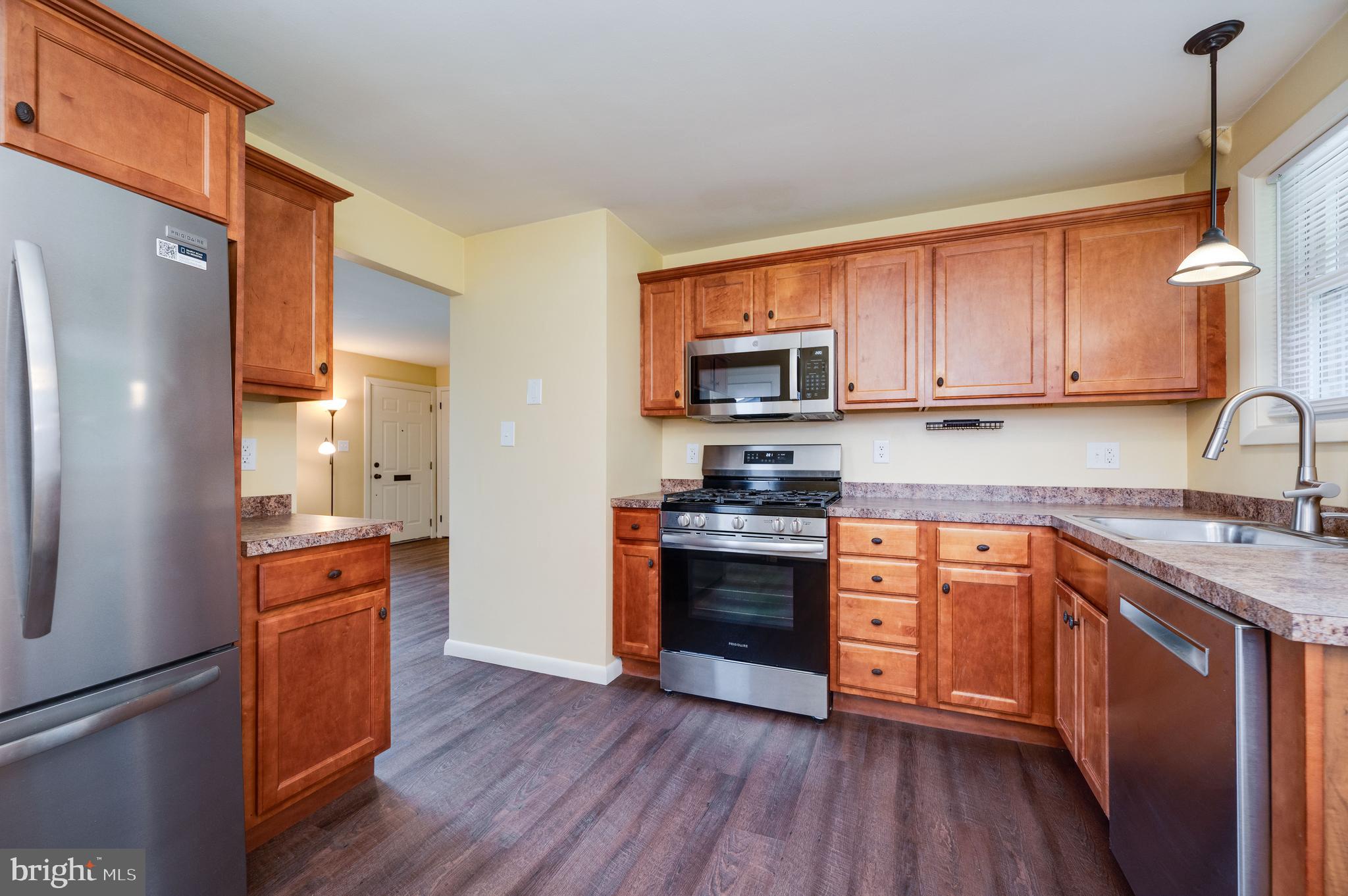 1392 New Holland Road Reading, PA 19607 - Photo 14 of 27 a kitchen with stainless steel appliances granite countertop a stove top oven a refrigerator a sink and dishwasher with wooden floor
