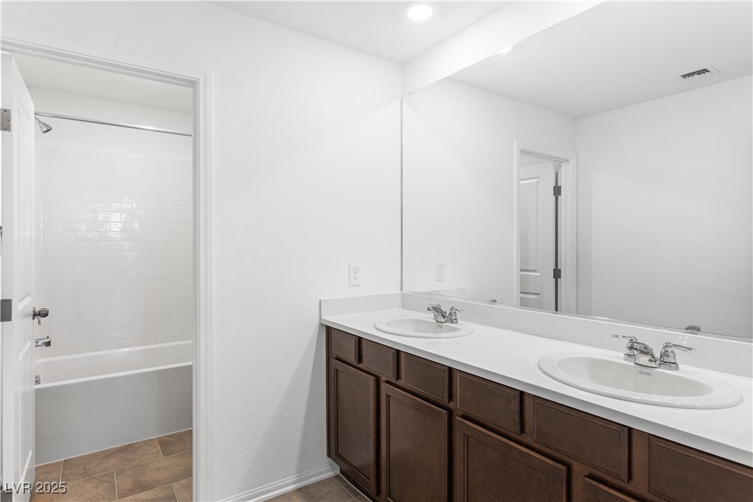 5678 Spring Trellis Street Las Vegas, NV 89113 - Photo 13 of 22 Full bathroom featuring double vanity, shower / bath combination, and dark tile patterned floors