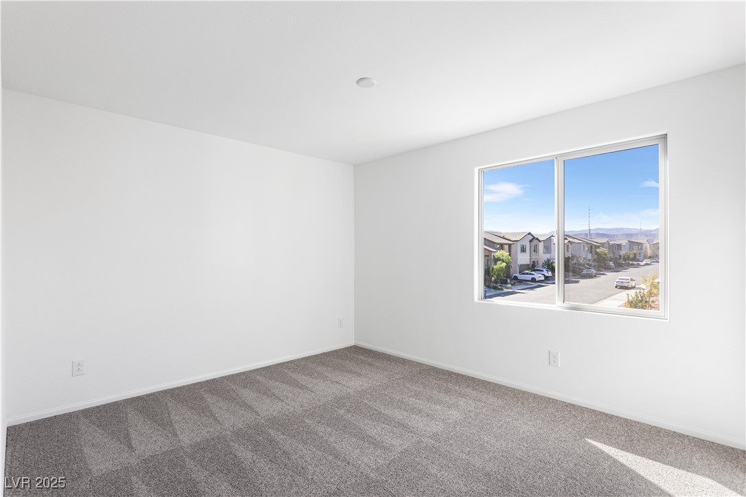 5678 Spring Trellis Street Las Vegas, NV 89113 - Photo 9 of 22 Carpeted spare room with baseboards
