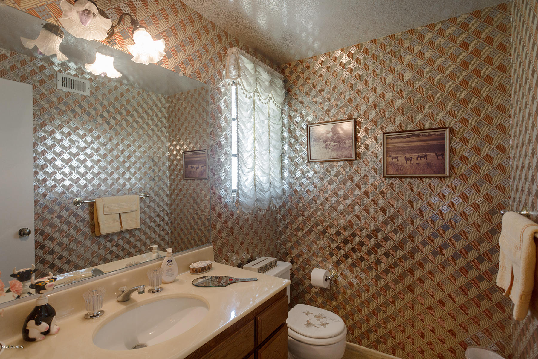 19700 Strathern Street Winnetka, CA 91306 - Photo 13 of 25 a bathroom with a sink a toilet and shower curtain