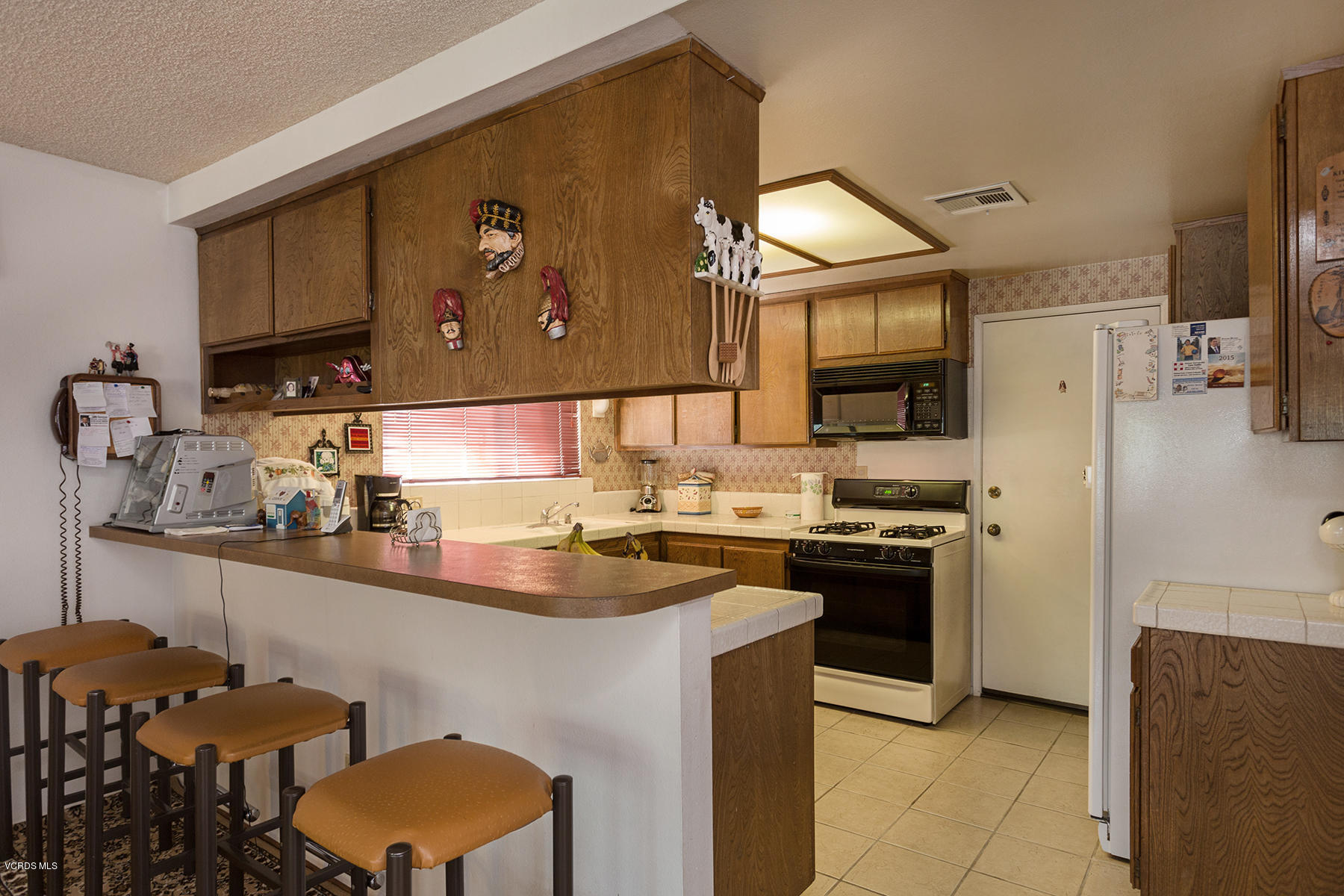 19700 Strathern Street Winnetka, CA 91306 - Photo 8 of 25 a kitchen with stainless steel appliances a sink cabinets and refrigerator