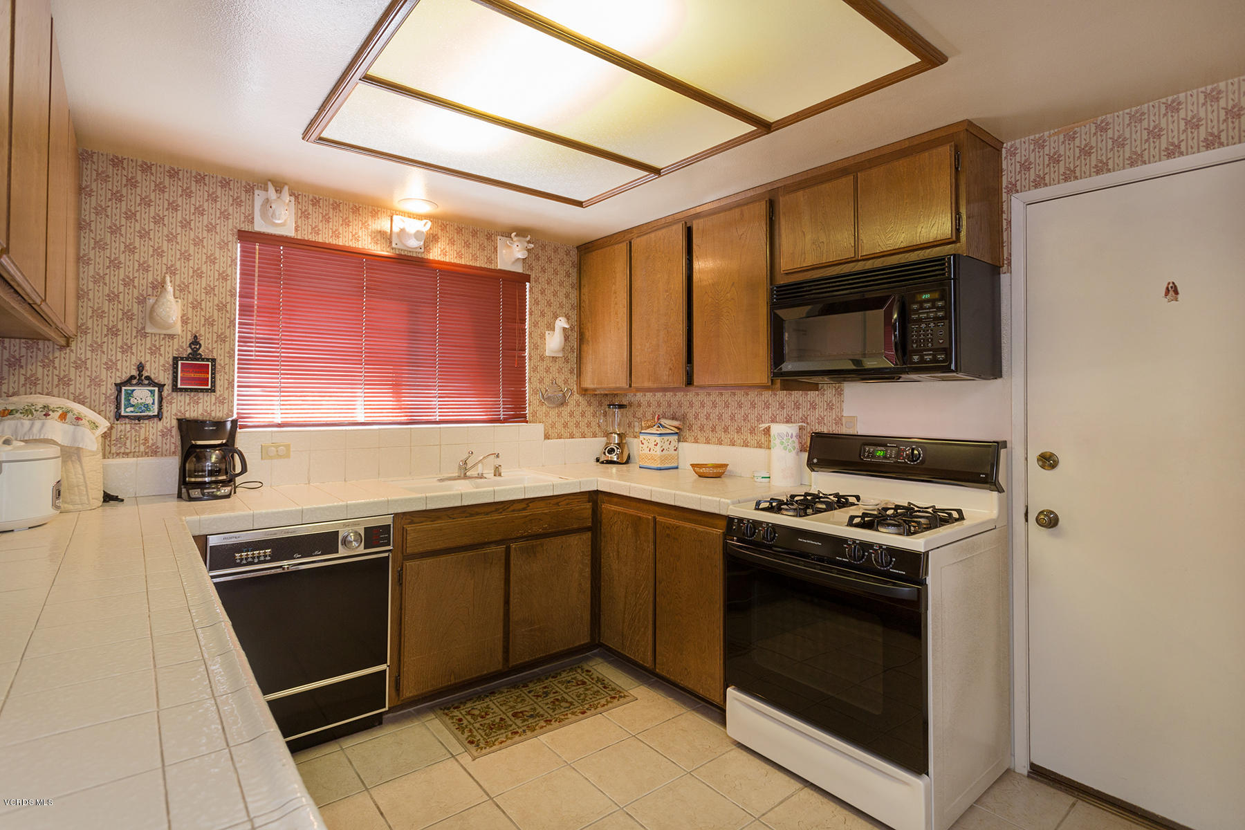 19700 Strathern Street Winnetka, CA 91306 - Photo 9 of 25 a kitchen with stainless steel appliances granite countertop a stove microwave and sink