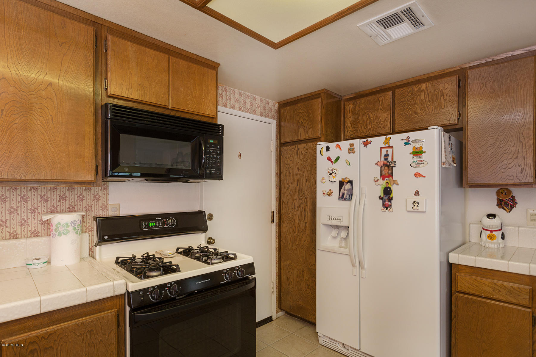 19700 Strathern Street Winnetka, CA 91306 - Photo 10 of 25 a white refrigerator freezer and a stove sitting inside of a kitchen